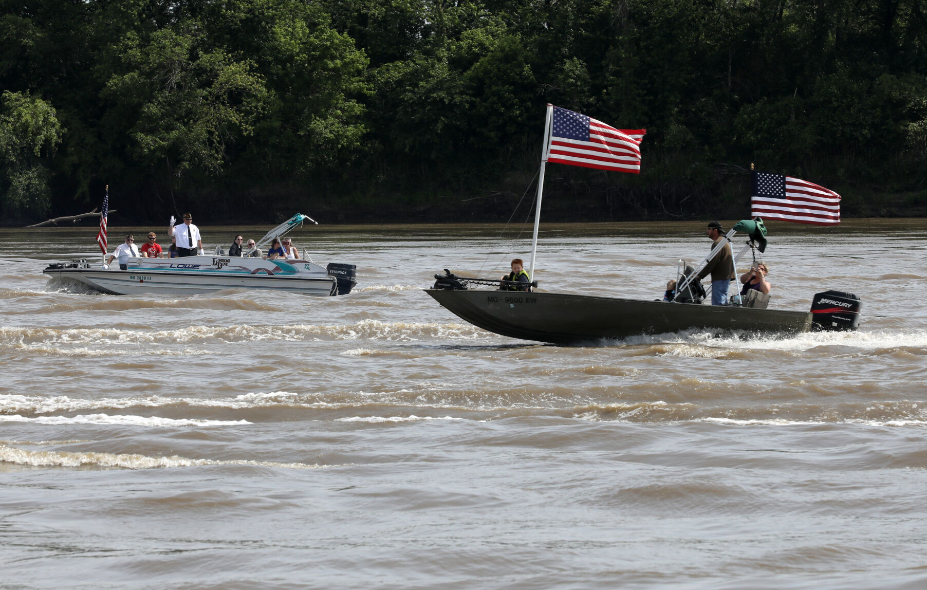 People steer boats up the river